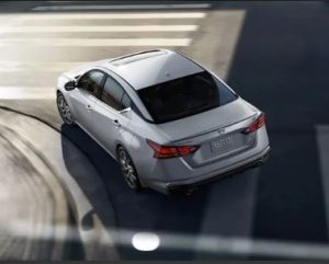 Top view of a silver 2023 Nissan Altima making a turn on a street near Indianapolis, Indiana