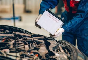 A service technician performing a car battery replacement near Indianapolis, Indiana.