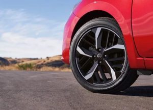 A close-up photo of the front left wheel on a red 2024 Nissan Versa near Indianapolis, Indiana