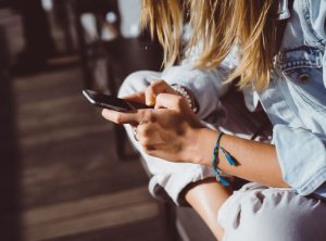 A person looking at their phone and reading about the 2025 Nissan LEAF near Indianapolis, Indiana