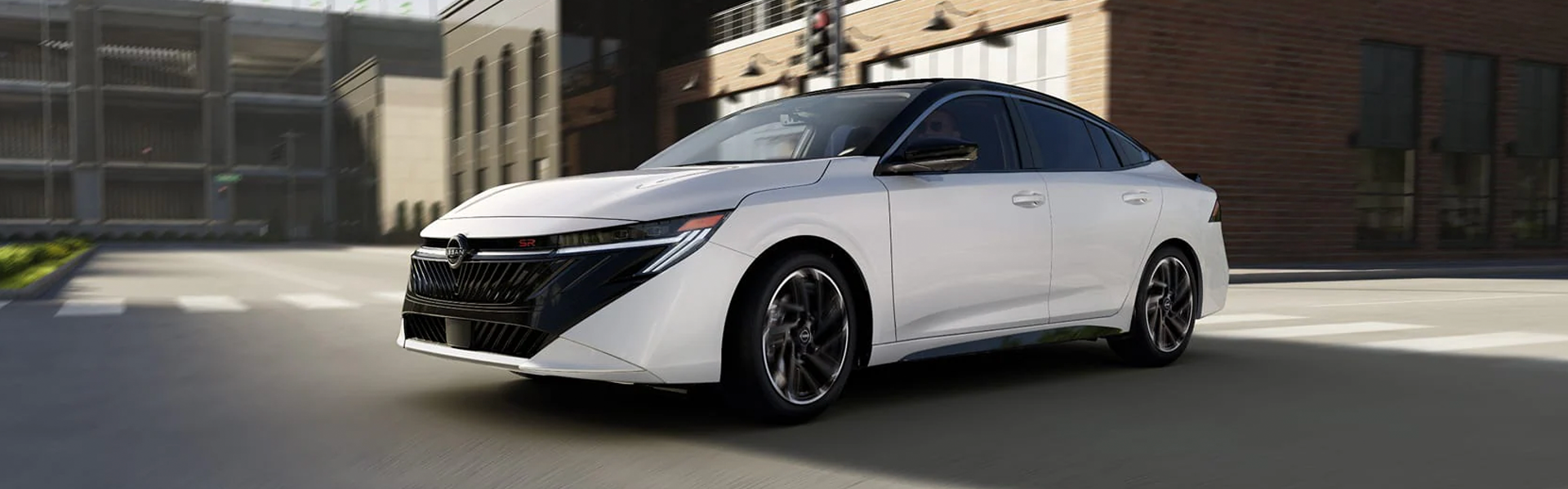 Nissan sedan driving on city street