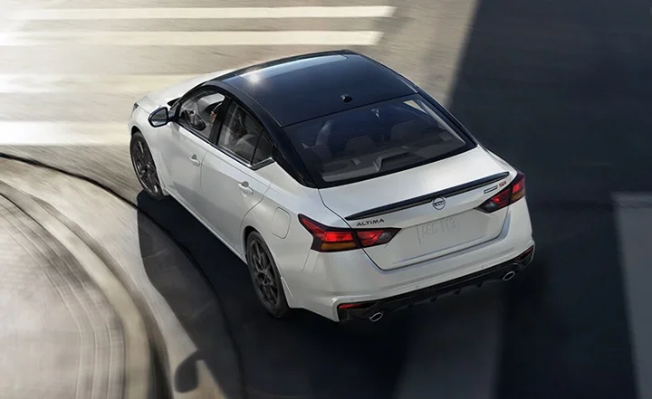 Overhead view of a white Nissan Altima driving on a road