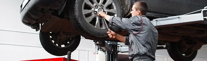 Nissan technician working on a car raised on a service lift