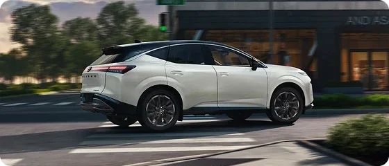 2026 Nissan Murano Platinum AWD in white driving through a city intersection, side view