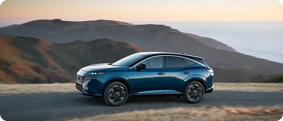 2026 Nissan Murano Platinum AWD in blue driving on a coastal ridge road at dusk, side view