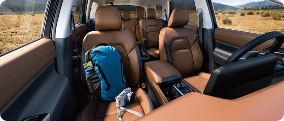Interior of the 2026 Nissan Pathfinder Platinum 4WD showing tan semi-aniline leather seats across the front and second rows, with a backpack on the second-row seat