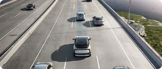 Overhead view of a 2026 Nissan Kicks on a highway, sensor beams tracking the vehicle ahead to illustrate Nissan Safety Shield 360