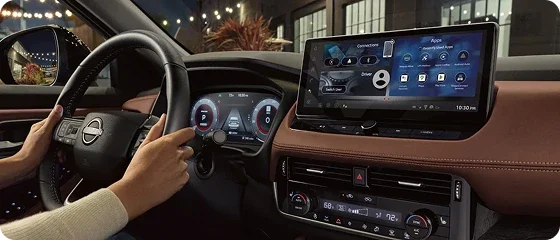 Driver's view inside the 2026 Nissan Rogue Platinum AWD at night, showing the 12.3-inch digital instrument cluster and 12.3-inch NissanConnect touchscreen