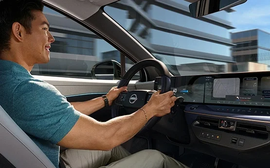 Driver at the wheel of a new Nissan with the touchscreen in view