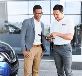Ed Martin Nissan salesperson shaking hands with a customer in the showroom