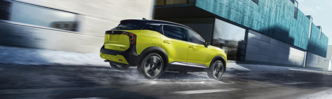 Yellow Nissan SUV driving along a wet city street