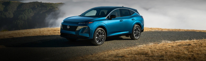 Blue Nissan SUV parked on a hilltop road above low clouds
