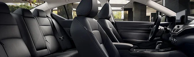Interior of the 2026 Nissan Altima showing the black front and rear seats and the dashboard