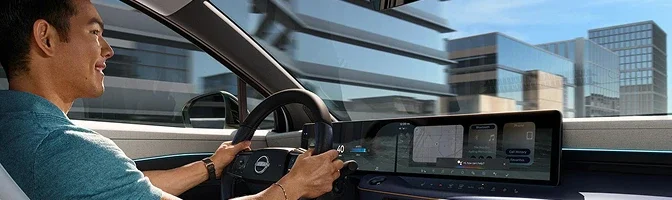 Driver at the wheel of a 2026 Nissan LEAF with navigation on the center screen
