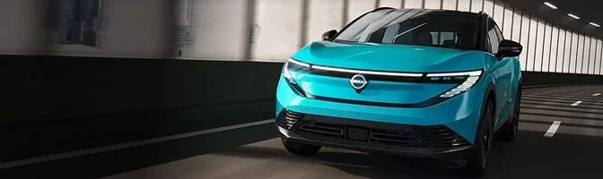 Front view of a turquoise 2026 Nissan LEAF driving through a tunnel with its lights on