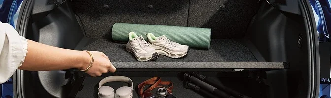 Open cargo area of the 2026 Nissan LEAF with a yoga mat and trainers above the load floor