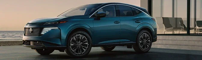Teal 2026 Nissan Murano parked on a seafront driveway at dusk