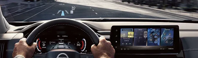 Driver's view of the Pathfinder wheel, gauge cluster and head-up display on the road
