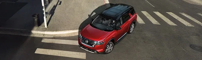 Overhead view of a red 2026 Nissan Pathfinder crossing a city intersection