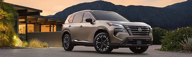 Bronze 2026 Nissan Rogue parked outside a modern house at dusk