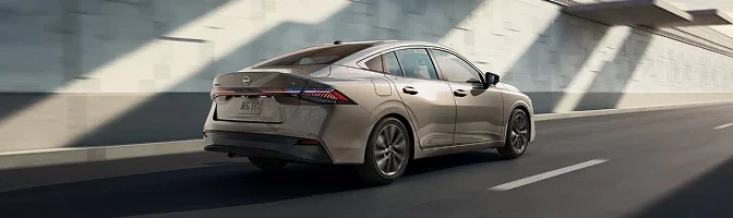 Bronze 2026 Nissan Sentra driving away along a sunlit underpass