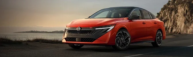 Orange 2026 Nissan Sentra parked on a coastal road at dusk