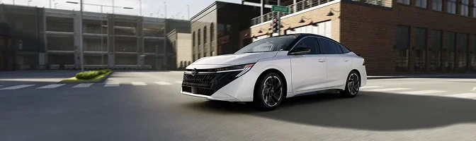 White 2026 Nissan Sentra driving through a quiet city intersection