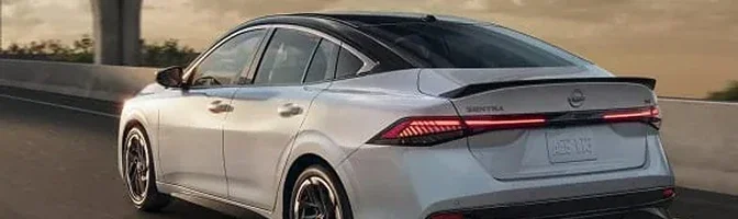 Rear three-quarter view of a silver 2026 Nissan Sentra with a black roof on the highway