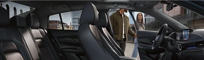 Interior of the 2026 Nissan Sentra with two people at the open driver's door